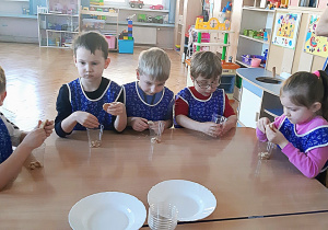 Dzieci przygotowują deser z kruchych ciasteczek.